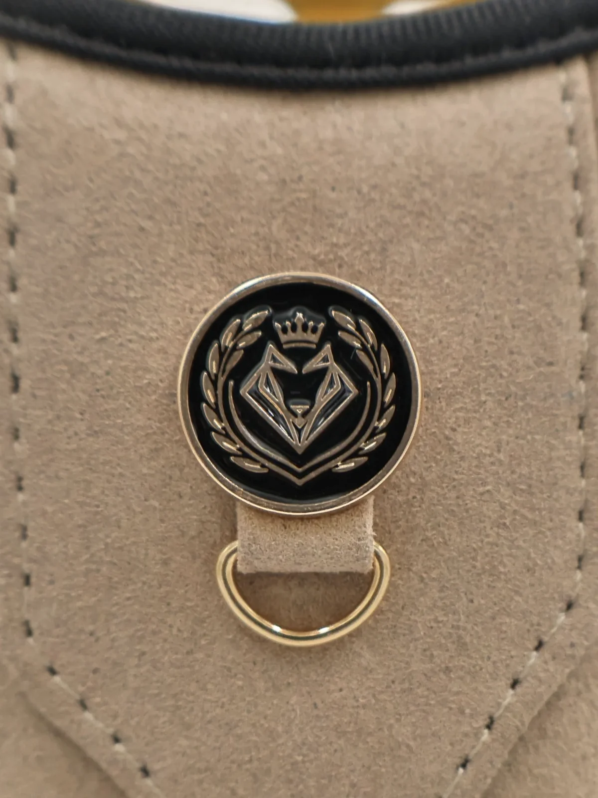 The enamelled VELKYNO crest button on the taupe chest plate