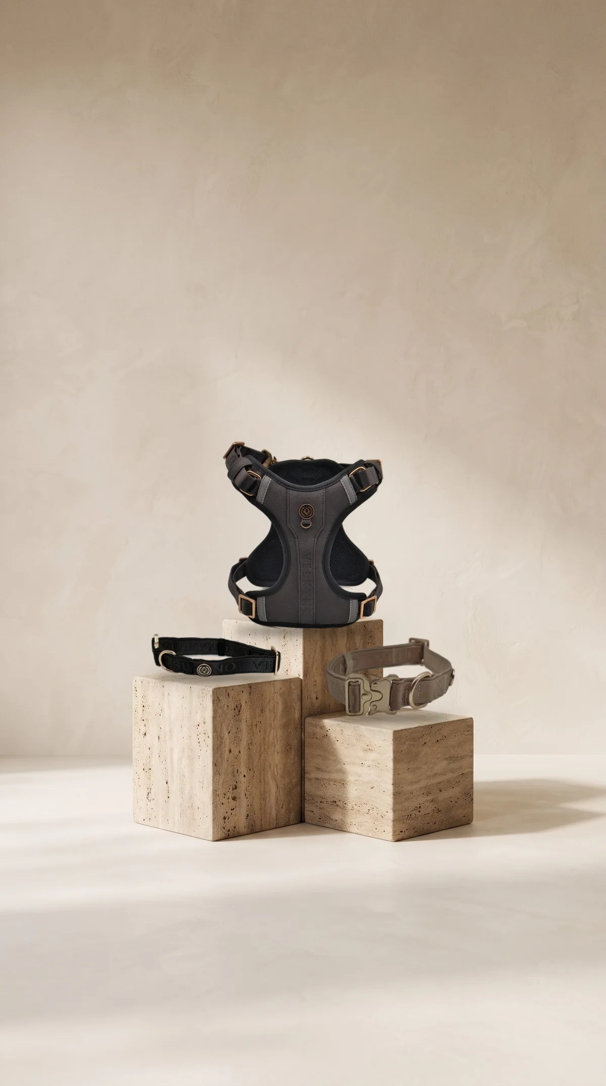Graphite L’Aplomb Tech Harness and Graphite and Taupe collars on travertine plinths