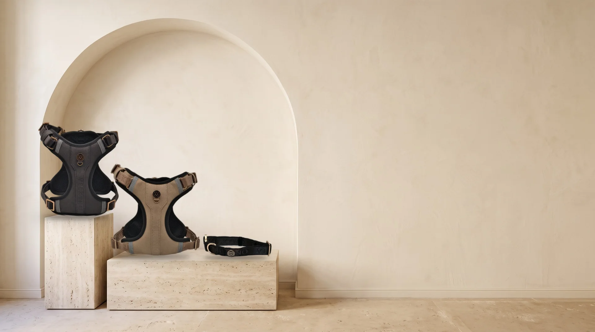 Graphite and Taupe L'Aplomb Tech Harnesses and a Graphite collar on travertine plinths beneath an arch